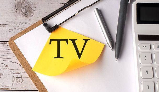 TV TERMINAL WALUE woord op geel kleverig met rekenmachine, pen en klembord - Foto, afbeelding