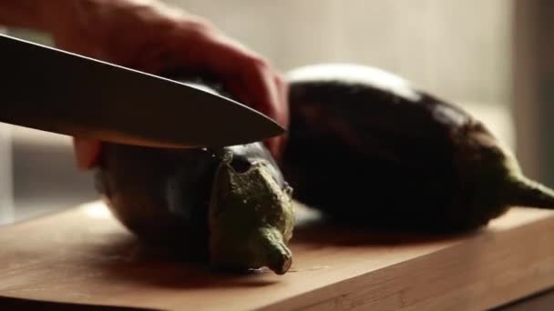 ακριβής προετοιμασία: γυναικεία χέρια κοπής μελιτζάνας σε κύβους σε ξύλινη σανίδα γκρο πλαν - Πλάνα, βίντεο