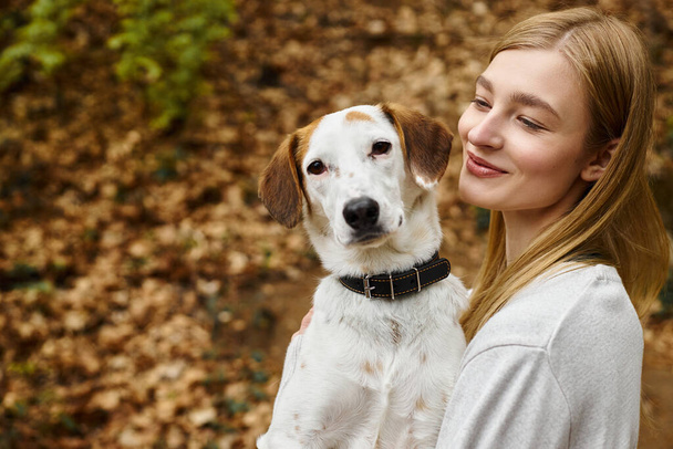 Glückliches Mädchen, das mit seinem Haustier interagiert, schaut auf Hundewanderruhe mit Berg- und Waldblick - Foto, Bild