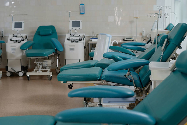 Mukavat nojatuolit verenluovuttajille järjestetty riviin tyhjään terveyskeskukseen - Valokuva, kuva