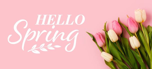 Schöne Tulpen und Text HELLO, FRÜHLING auf rosa Hintergrund - Foto, Bild