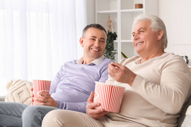 Ältere Brüder mit Popcorn-Film zu Hause - Foto, Bild