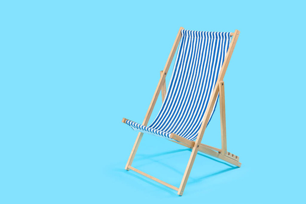 silla de cubierta rayada sobre fondo azul - Foto, Imagen