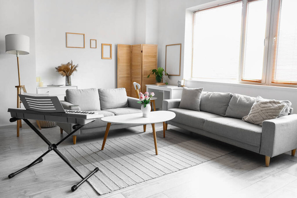 Interiér světlého obývacího pokoje s pohovkami a syntezátorem - Fotografie, Obrázek