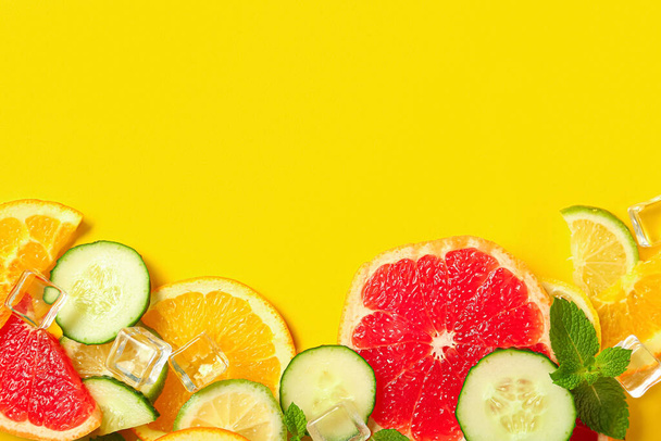 Komposition mit Eiswürfeln und frischen Zutaten für Limonade auf gelbem Hintergrund - Foto, Bild