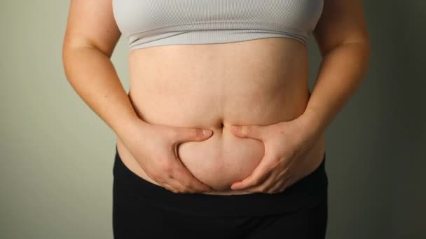 太りすぎの女性の大きな腹に脂肪の折り畳みを閉じる. 過剰な体重,肥満の女性,ダイエット,過体重の問題の概念. 高品質のフルHD映像 - 映像、動画