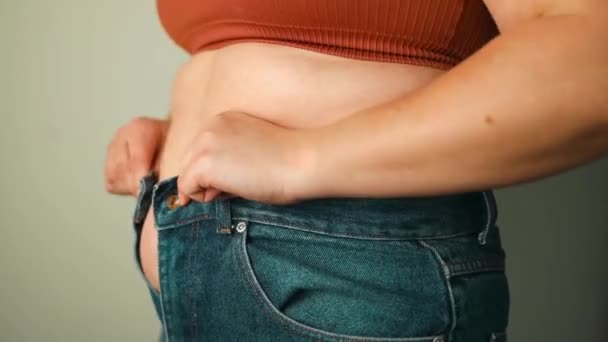 Lähikuva rasvaa taittuu iso vatsa ylipainoinen nainen. Ylipainon, lihavien naisten, ruokavalion ja ylipainoisten ongelmien käsite. Laadukas FullHD kuvamateriaalia - Materiaali, video
