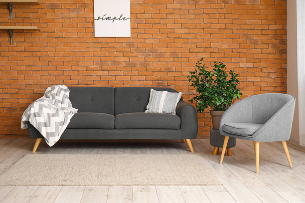 Wnętrze nowoczesnego salonu ze stylowym dywanem, fotelem i szarą sofą - Zdjęcie, obraz