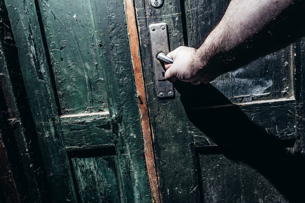 Fénykép férfi kézfogás és nyitó régi elavult poros ajtó. Horror-koncepció. - Fotó, kép