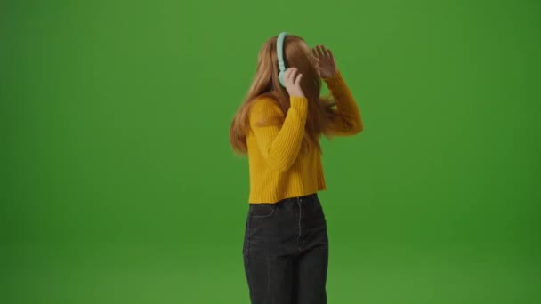 Green Screen. Attractive Teenage Girl In Headphones Joyfully Dances. Modern Youth Culture Trends, Popular Platforms And Social Networks. Instagram Stories, TikTok Dances. - Footage, Video