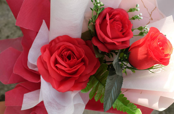 романтичне кохання і день Святого Валентина з красивим букетом квітів червоних троянд ізольовані на фоні акторської підлоги. Концепція дня Святого Валентина Вид збоку, простір для копіювання тексту - Фото, зображення