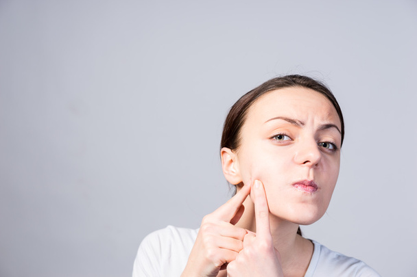 Young Woman Pricking Blackheads on her Cheek - Photo, Image