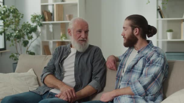Deep conversation between generations young man and elder on the couch discuss life, experience exchange, heartfelt communication, emotional support, understanding differences mentoring, family values - Footage, Video