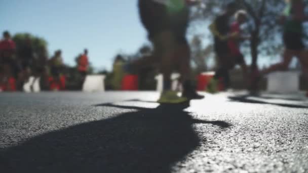 Läufer in verschiedenen Silhouetten rasen bei sommerlicher Dämmerung beim Stadtmarathon über die Ziellinie. - Filmmaterial, Video