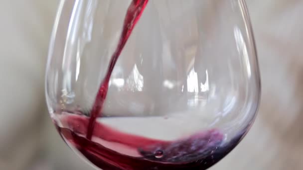 Червоне вино кружляє в кришталевому склі, крупним планом червоне вино наливається і крутиться в склянку, підкреслюючи напої яскравим кольором і рухом рідини - Кадри, відео