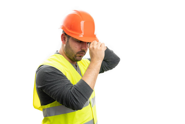Uomo costruttore adulto indossa giallo giubbotto fluorescente organizzare casco di sicurezza arancione sempre pronto per il lavoro con copyspace vuoto isolato su sfondo bianco - Foto, immagini