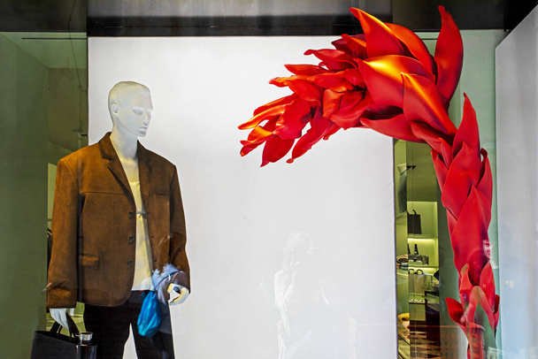 stylowa brązowa męska kurtka z męską torebką w oknie sklepu odzieżowego. Styl i moda - Zdjęcie, obraz