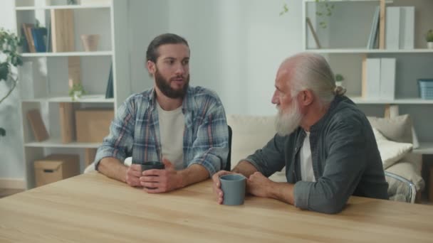 Familiegesprek: jonge en oudere mannen praten over het leven, psychologische ondersteuning voor elkaar, intergenerationele dialoog, oprechte troost, advies en wijsheid, warme communicatie - Video