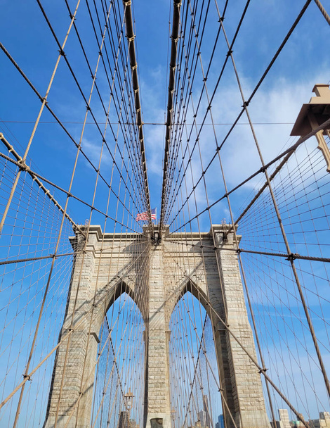 A striking view of the Brooklyn Bridges intricate cable patterns against a clear blue sky. - Photo, Image