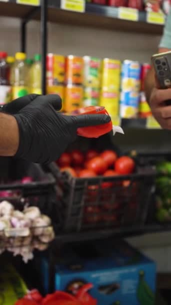 Persona anonima che paga senza contatto con il suo telefono in un negozio di frutta in Cile. Pagamento senza fili. - Filmati, video