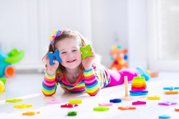 klein meisje spelen met houten speelgoed - Foto, afbeelding
