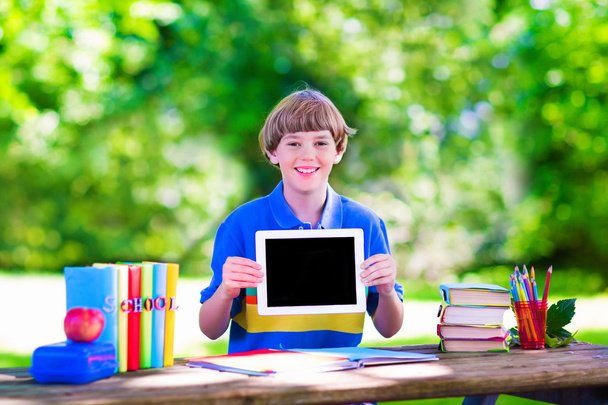 Ребенок с планшетным компьютером на школьном дворе
 - Фото, изображение