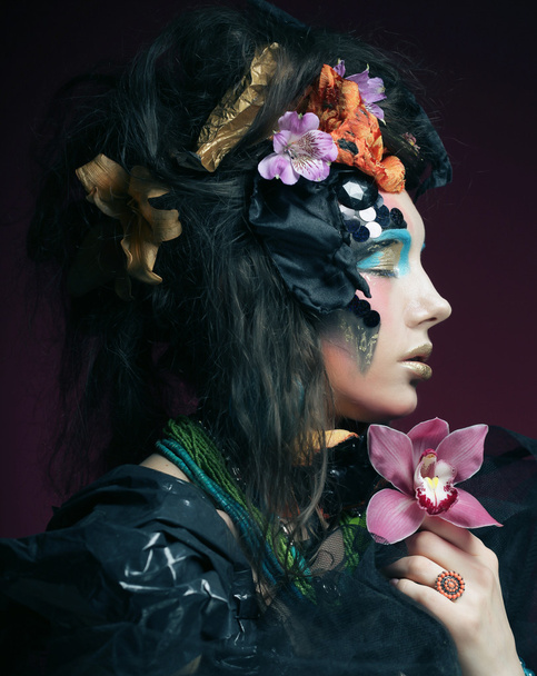 woman with creative make up holding pink flower - Fotoğraf, Görsel