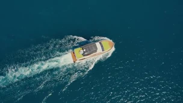 Yacht con lettini a poppa galleggiante sulla superficie dell'acqua in estate, vista aerea dall'alto. - Filmati, video