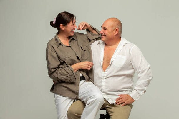 Aikuisen pariskunnan muotokuva. Iloinen nauraa hauska pari, kaksi ystävää, vanhukset harmaakarvainen brunette mies rento vaatteet seisoo, halaus ja kommunikoi - Valokuva, kuva