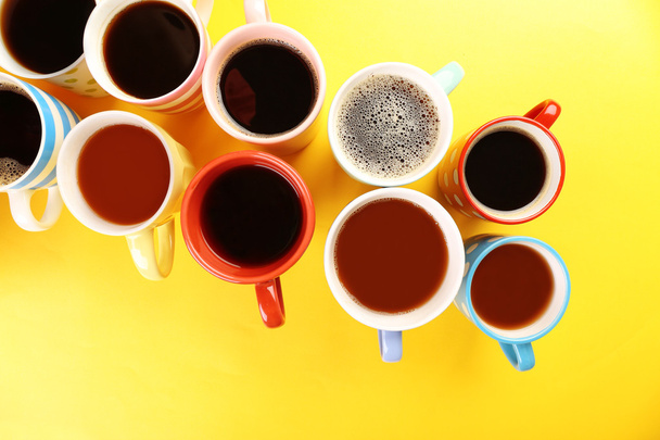 Багато чашок кави на кольоровому столі, крупним планом
 - Фото, зображення