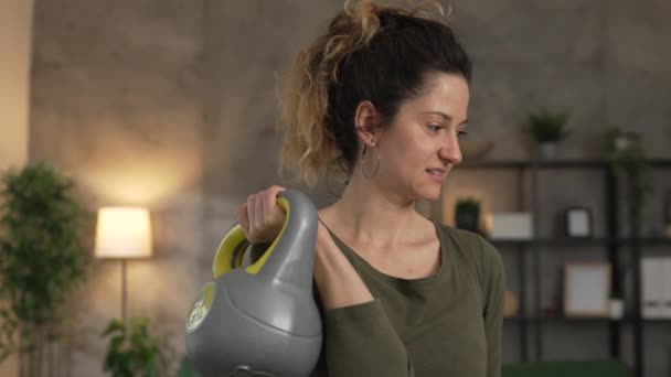Una mujer adulta entrenando en casa uso kettlebell girya peso - Imágenes, Vídeo