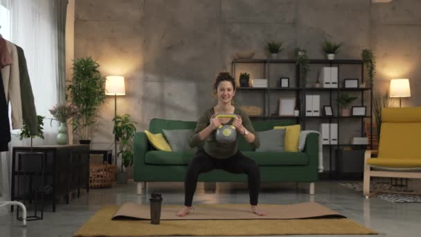 Een volwassen vrouw training thuis gebruik kettlebell girya gewicht - Video