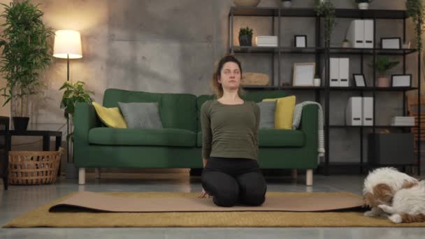 Женщина практикует йогу на коврике в гостиной на дому замедленной съемки - Кадры, видео