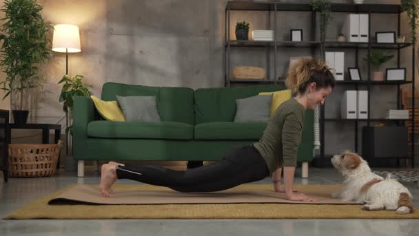 Жінка практикує йогу на килимку у вітальні вдома повільний рух - Кадри, відео