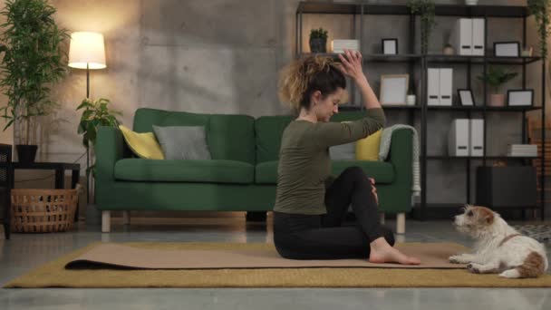 Γυναίκα πρακτική γιόγκα στο χαλί στο σαλόνι στο σπίτι αργή κίνηση - Πλάνα, βίντεο