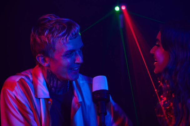 Szczęśliwa para ciesząca się śpiewaniem w karaoke na pierwszej randce - Zdjęcie, obraz