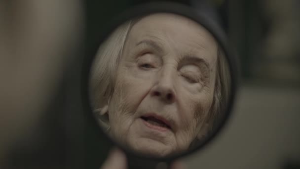 Παλιά γυναίκα πρόσωπο βλέποντας τον εαυτό της στον καθρέφτη Σκέψη για το παρελθόν - Πλάνα, βίντεο
