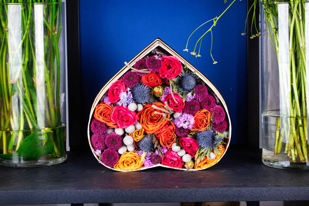 Фотография, демонстрирующая вазу, наполненную цветами, помещенную рядом с вазами, наполненными водой, предлагая безмятежный и освежающий дисплей. - Фото, изображение