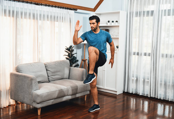 Homem atlético e esportivo correndo postura em casa sessão de exercícios corporais para se encaixar físico e estilo de vida esportivo saudável em casa. Gaiety treino de exercícios em casa. - Foto, Imagem