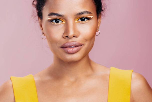 Nainen muotokuva tyyli musta kosmetiikka kasvot kosmeettinen malli keltainen värikäs kaunis kauneus meikki afrikkalainen iho studio hymy muoti kopio vaaleanpunainen tilaa luova - Valokuva, kuva
