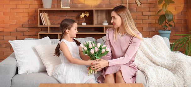 Petite fille mignonne saluant sa mère avec des tulipes à la maison - Photo, image