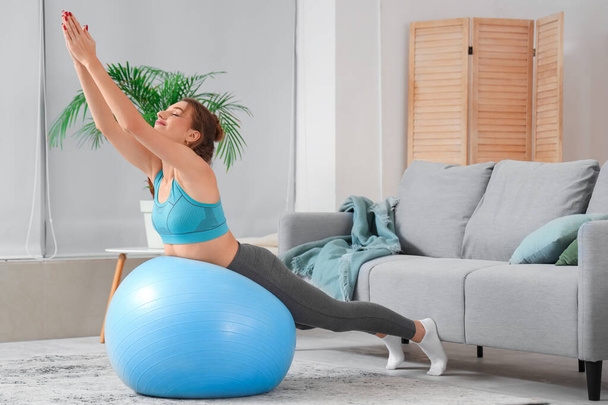 Young woman with fitball doing pilates at home - Photo, Image