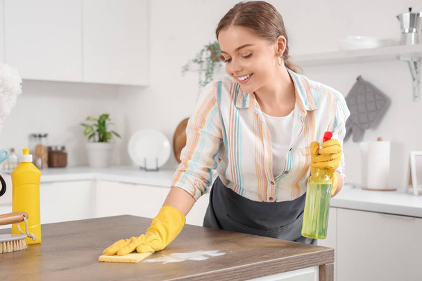 Tavolo pulizia inserviente donna con detergente in cucina - Foto, immagini