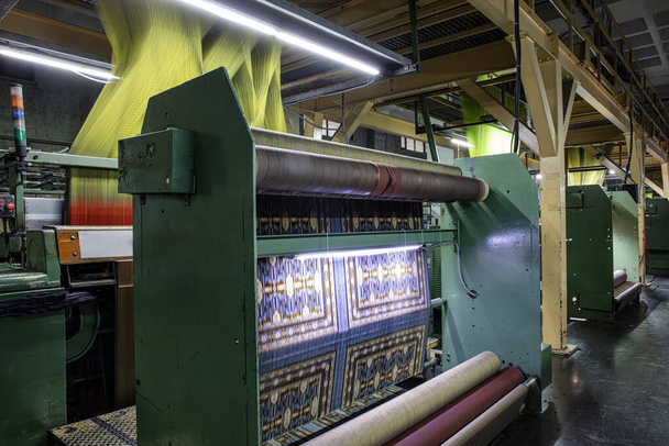 Синтетичні нитки для килимової фабрики, виробництва килимів, ткацьких верстатів. Інтер'єр килимово-тканинної фабрики. Стійка для швейних ниток в текстильному ткацькому заводі. - Фото, зображення