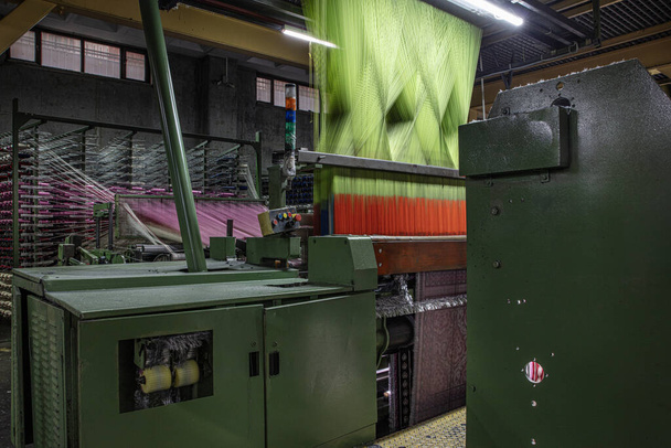 Синтетичні нитки для килимової фабрики, виробництва килимів, ткацьких верстатів. Інтер'єр килимово-тканинної фабрики. Стійка для швейних ниток в текстильному ткацькому заводі. - Фото, зображення