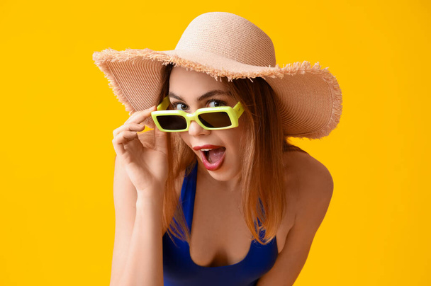 Красивая счастливая молодая женщина в купальнике на желтом фоне - Фото, изображение