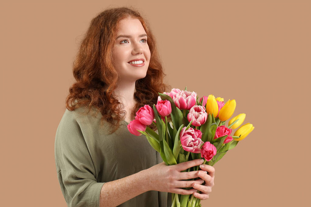Onnellinen nuori nainen kimppu kauniita tulppaaneja ruskealla taustalla. Kansainvälinen naistenpäivä - Valokuva, kuva