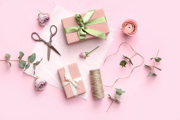 Cajas de regalo con papel de regalo y hermosas rosas sobre fondo rosa. Día Internacional de la Mujer - Foto, Imagen