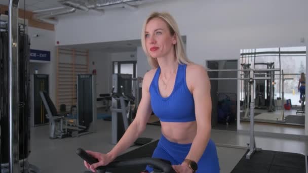 Young woman cardio workout on exercise bike in gym. Active lifestyle. Beautiful figure of a woman. - Footage, Video