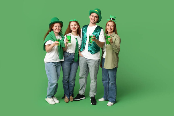Ομάδα ανθρώπων με μπύρα σε πράσινο φόντο. Γιορτή του Αγίου Πατρικίου - Φωτογραφία, εικόνα
